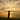 Woman silhouetted against a golden sunset on the beach with arms raised, representing freedom, vitality and empowerment during the menopausal transition